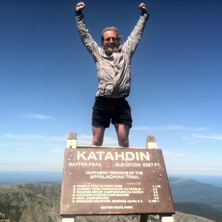 climber stands at mountain summit